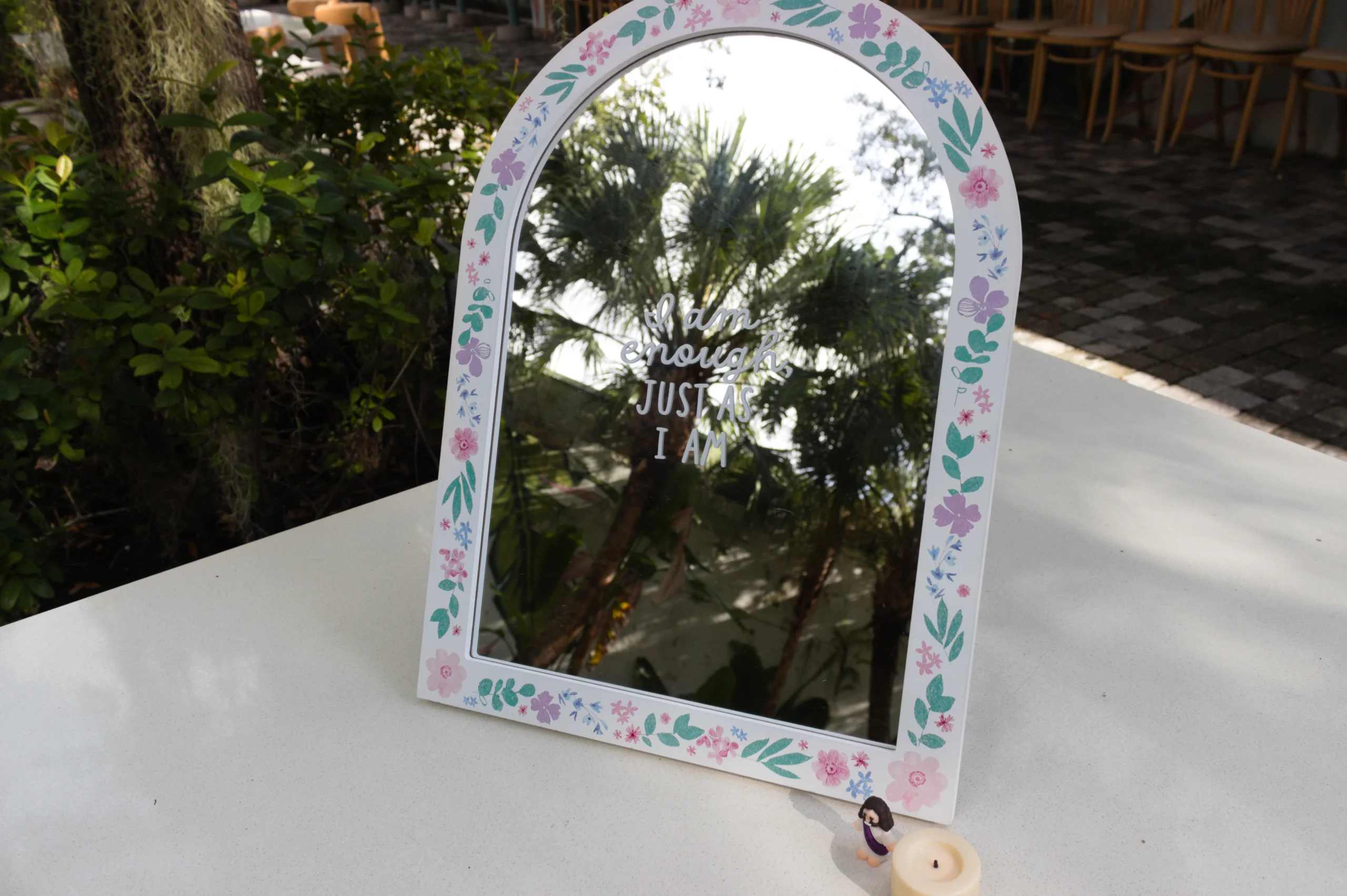 Hand-painted floral mirror with a reflection message at a Praise Break event